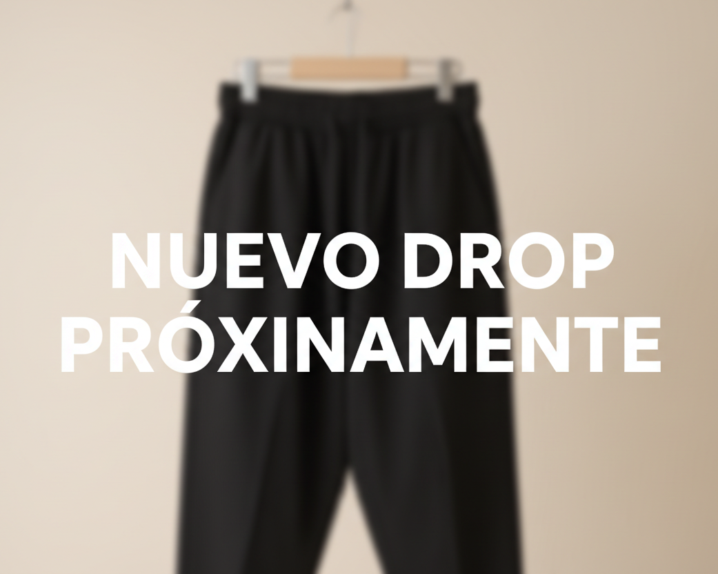 haz una imagen de un pantalón negro que este desenfocado el pantalón y delante escribe nuevo drop próximamente en el centro con las letras nítidas y un fondo claro